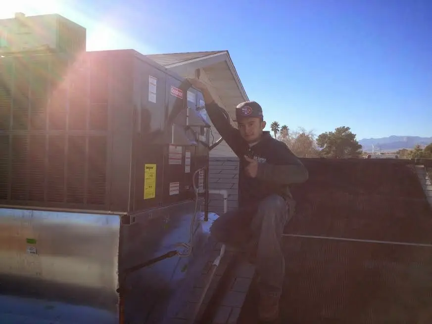 HVAC technician performing AC Tune-Up on a rooftop unit in Battle Ground